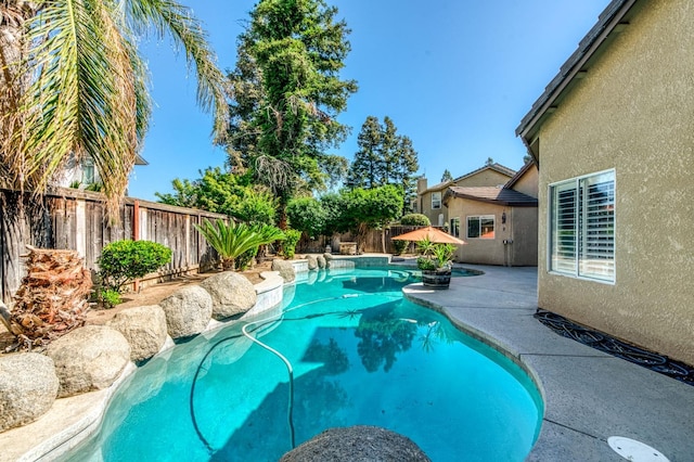 view of swimming pool with a fenced backyard and a patio