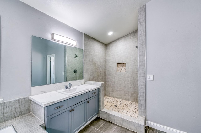 full bathroom with walk in shower, vanity, and tile patterned flooring