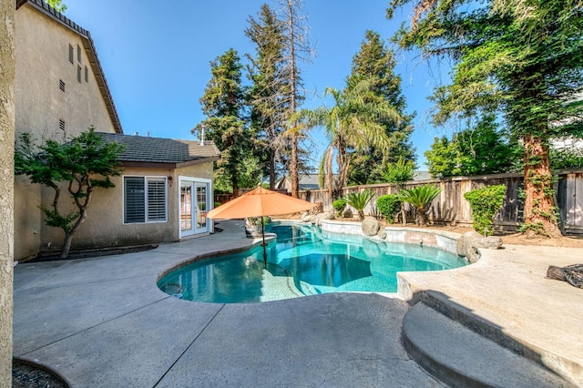 view of pool featuring a patio, a fenced backyard, and french doors