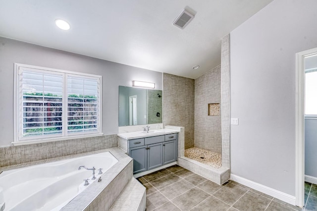 full bathroom featuring a garden tub, tile patterned floors, tiled shower, vanity, and baseboards