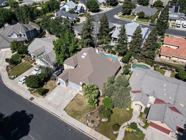 aerial view of property and surrounding area featuring nearby suburban area and a pool area