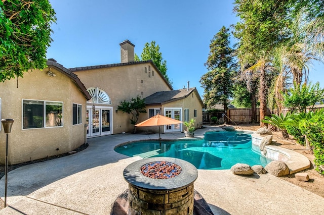 view of pool featuring french doors, a patio, and a fenced backyard