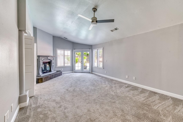 unfurnished living room with vaulted ceiling, a ceiling fan, carpet floors, baseboards, and a tile fireplace
