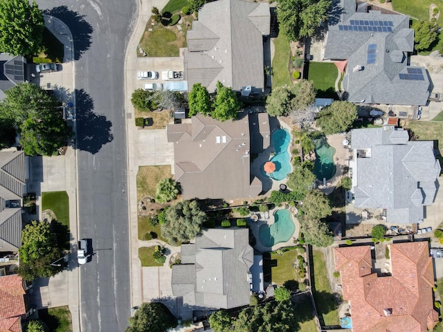 aerial view of property and surrounding area with a pool area and nearby suburban area