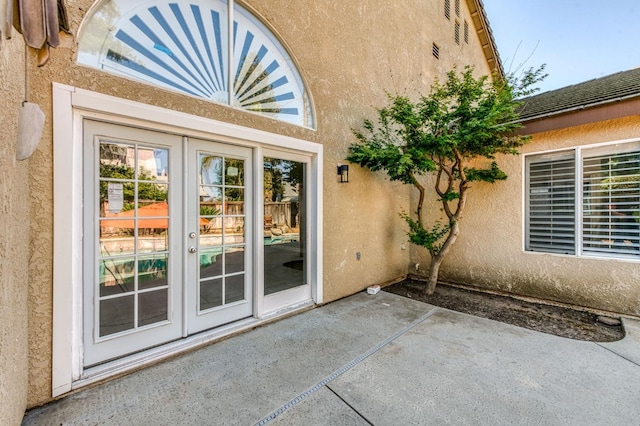 doorway to property featuring french doors, stucco siding, and a patio