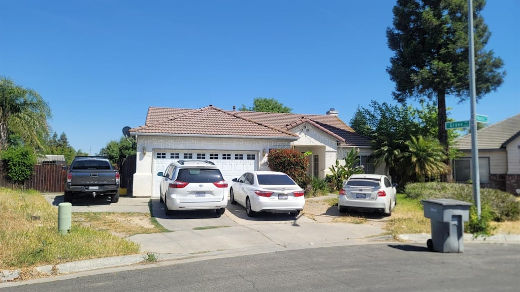 2485 S Manila Ave, Fresno, CA 93727 - single story home with a tiled roof, an attached garage, concrete driveway, and stucco siding