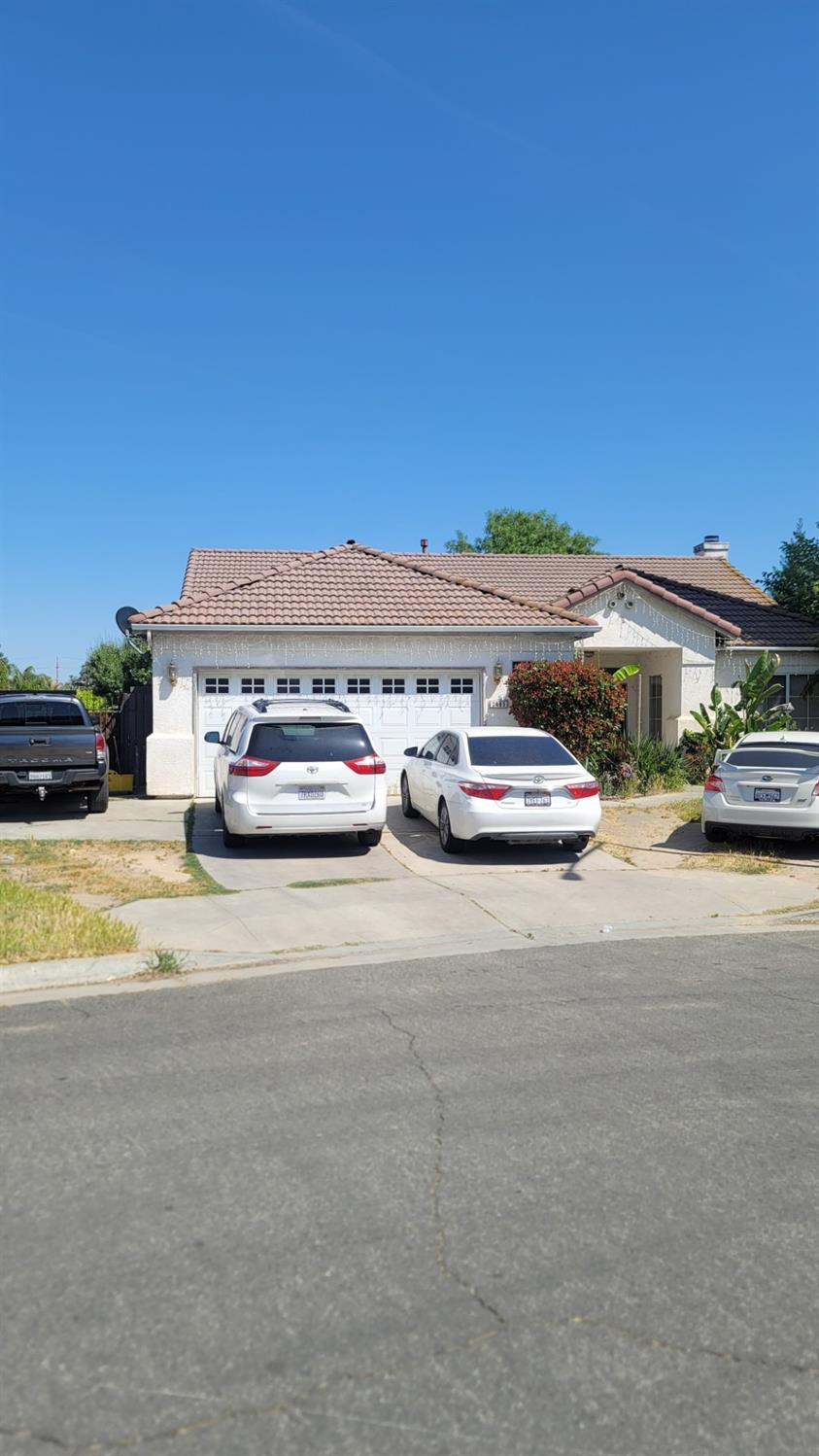 2485 S Manila Ave, Fresno, CA 93727 - view of front of home featuring an attached garage, a tile roof, driveway, and stucco siding