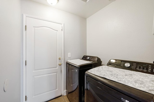 washroom with separate washer and dryer and light tile patterned floors