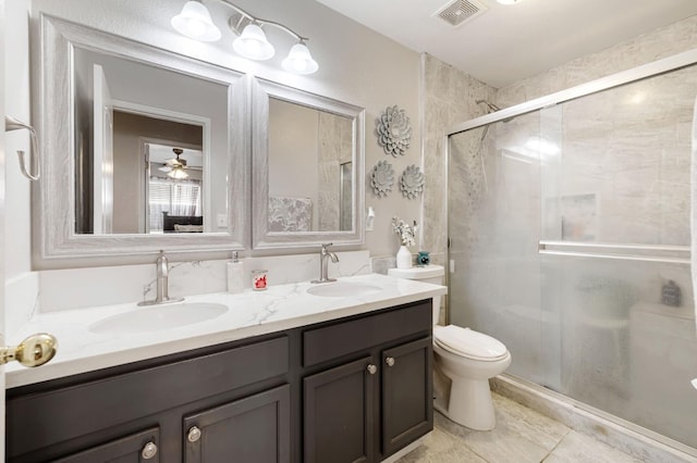 full bath featuring double vanity, a stall shower, toilet, and tile patterned flooring