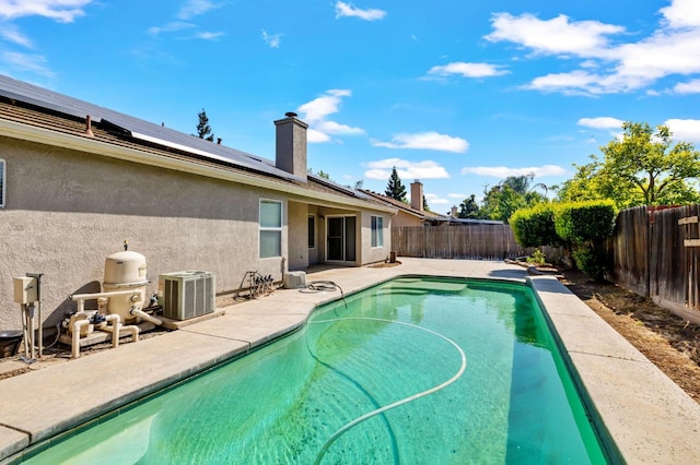 view of pool featuring a fenced backyard, central AC unit, and a patio
