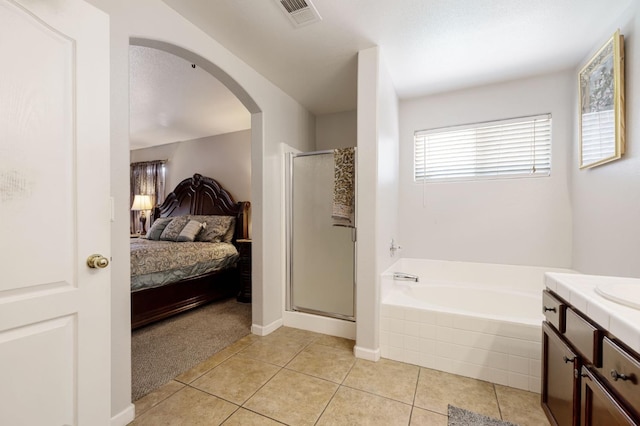 ensuite bathroom with a shower stall, a bath, tile patterned floors, and vanity
