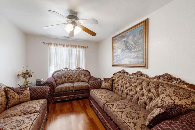 living area with dark wood-style flooring and a ceiling fan