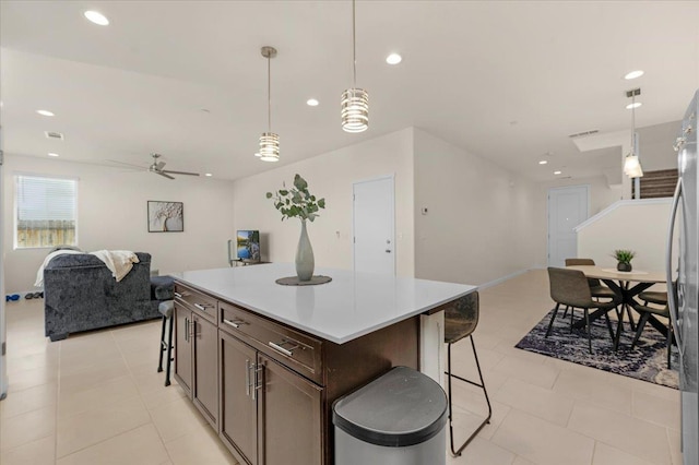 841 Corazon Ave, Clovis, CA 93619 - kitchen featuring open floor plan, ceiling fan, a center island, dark brown cabinets, and a breakfast bar