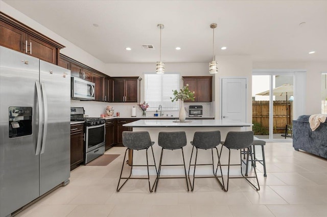 841 Corazon Ave, Clovis, CA 93619 - kitchen with appliances with stainless steel finishes, healthy amount of natural light, a breakfast bar area, dark brown cabinets, and recessed lighting