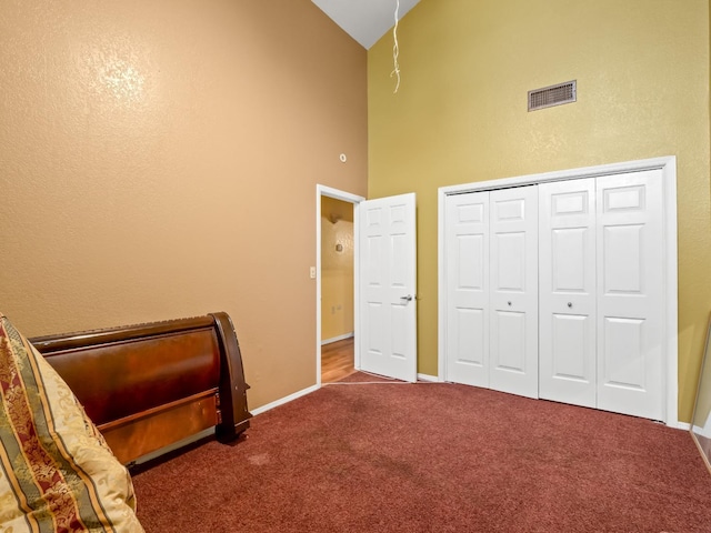 bedroom featuring high vaulted ceiling, carpet floors, baseboards, and a closet
