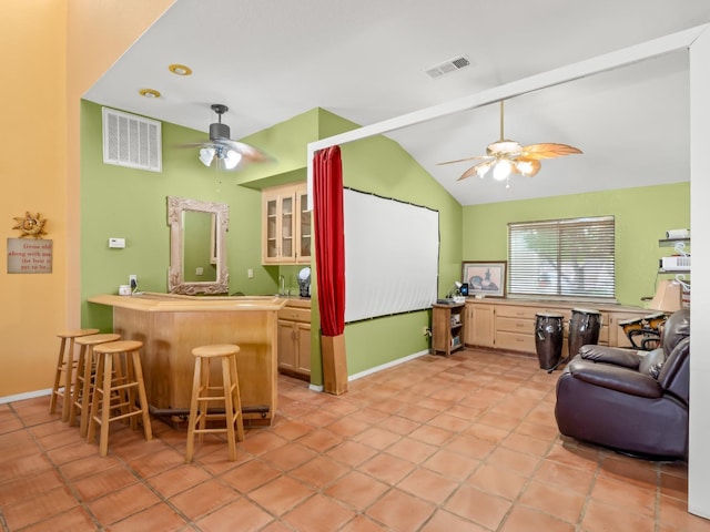 living room featuring a ceiling fan, lofted ceiling, and baseboards