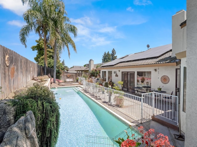 view of pool featuring a fenced backyard, a patio, and french doors