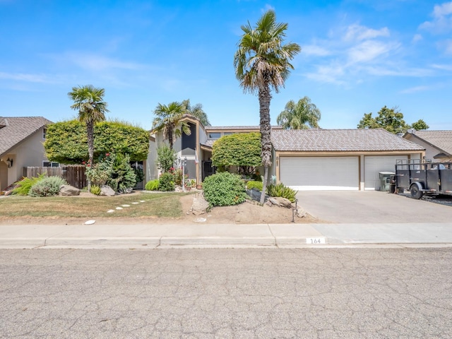 obstructed view of property with driveway, fence, a garage, stucco siding, and a tiled roof