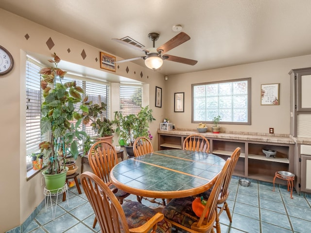 dining room with a ceiling fan and light tile patterned floors