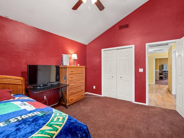 carpeted bedroom with high vaulted ceiling, a closet, and a ceiling fan