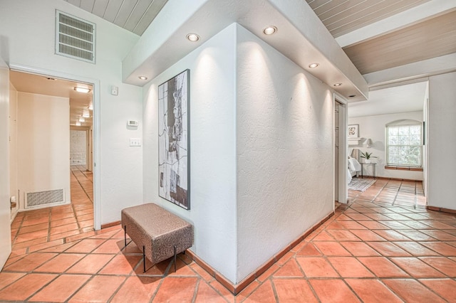 hallway featuring wooden ceiling, recessed lighting, baseboards, light tile patterned flooring, and a textured wall