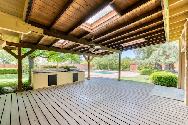 wooden terrace with a ceiling fan, a fenced backyard, area for grilling, and an outdoor pool