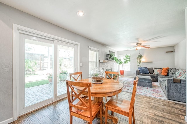 dining room featuring light wood-style floors, a ceiling fan, and baseboards