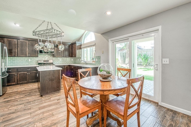 dining area featuring light wood finished floors, baseboards, recessed lighting, and lofted ceiling
