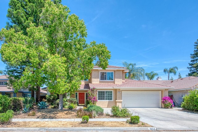 traditional-style home with stucco siding, an attached garage, concrete driveway, and a tile roof