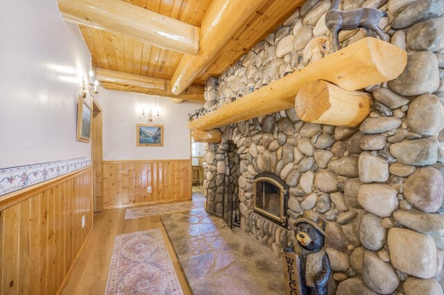 55585 Flintridge Dr, Shaver Lake, CA 93664 - unfurnished living room featuring a wainscoted wall, wood ceiling, beam ceiling, wood finished floors, and a fireplace