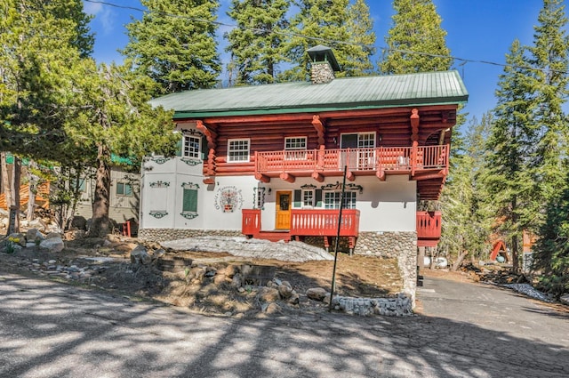 55585 Flintridge Dr, Shaver Lake, CA 93664 - log cabin with log exterior, a chimney, a balcony, and stone siding