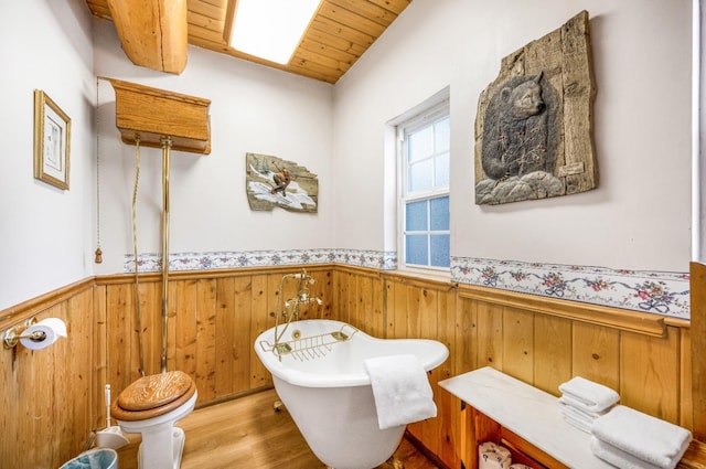 55585 Flintridge Dr, Shaver Lake, CA 93664 - bathroom featuring wainscoting, wood finished floors, a freestanding tub, wooden walls, and wooden ceiling