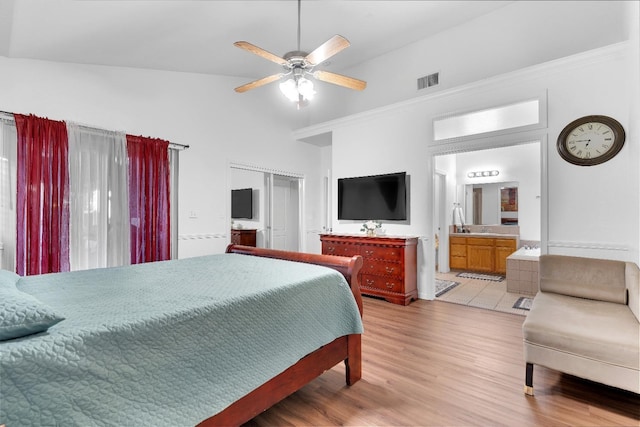 bedroom with high vaulted ceiling, a closet, light wood finished floors, ceiling fan, and ensuite bathroom