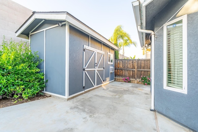 view of shed featuring fence