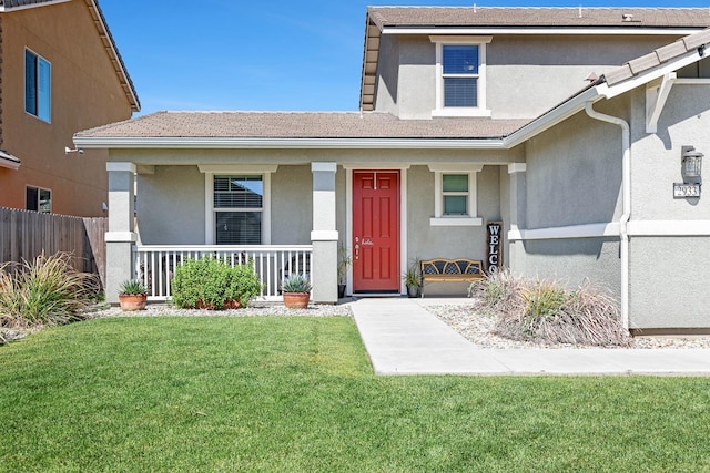 view of front of house featuring stucco siding, covered porch, and a tile roof