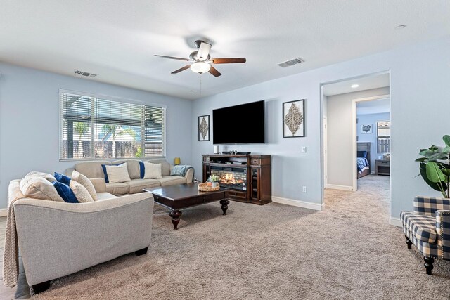 2933 N Hornet Ave, Fresno, CA 93737 - carpeted living area featuring a ceiling fan, baseboards, and a glass covered fireplace