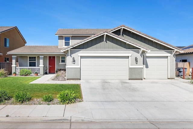 view of front of house with an attached garage, concrete driveway, a front yard, a porch, and board and batten siding