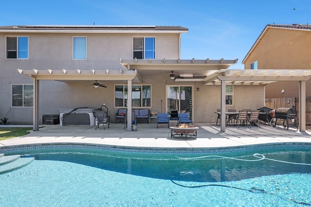 rear view of house featuring a pergola, ceiling fan, stucco siding, and an outdoor pool