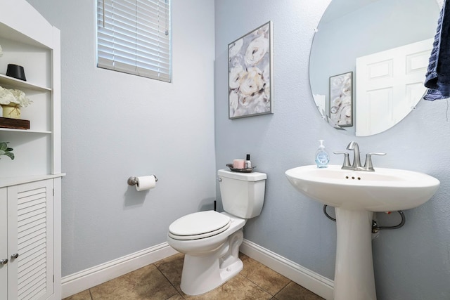 half bath featuring toilet, tile patterned flooring, and baseboards