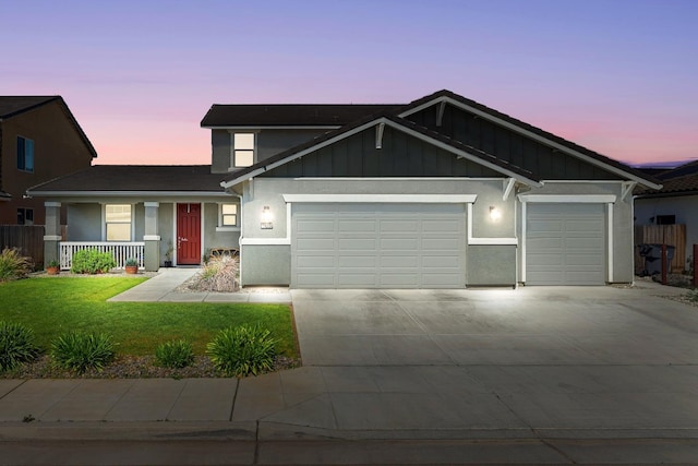 view of front of property with an attached garage, driveway, a lawn, a porch, and board and batten siding