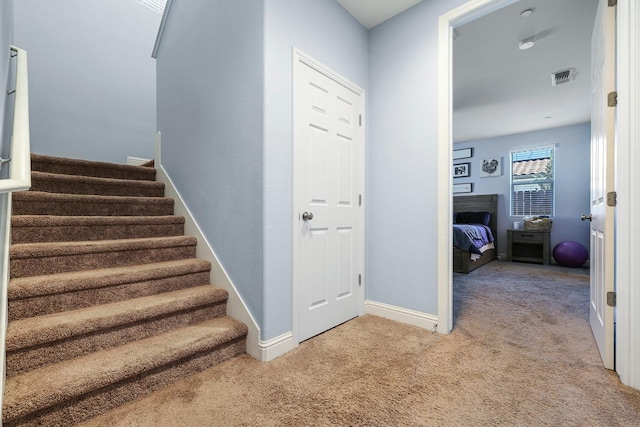 stairway featuring carpet floors and baseboards