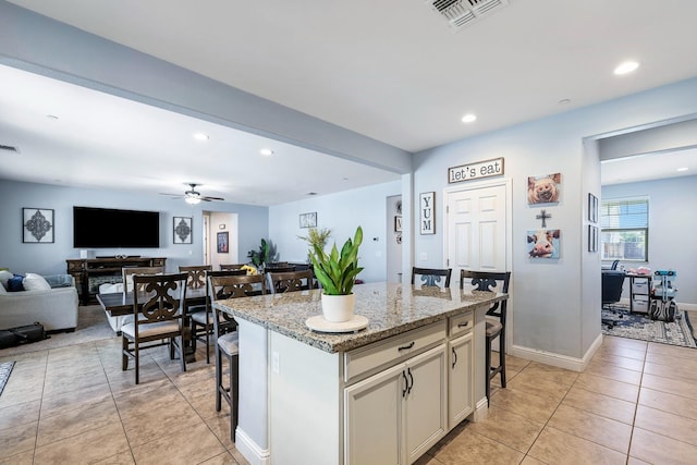 kitchen featuring a kitchen bar, open floor plan, light tile patterned floors, ceiling fan, and recessed lighting