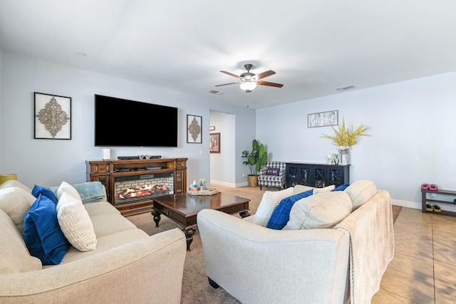 living room with a ceiling fan and baseboards
