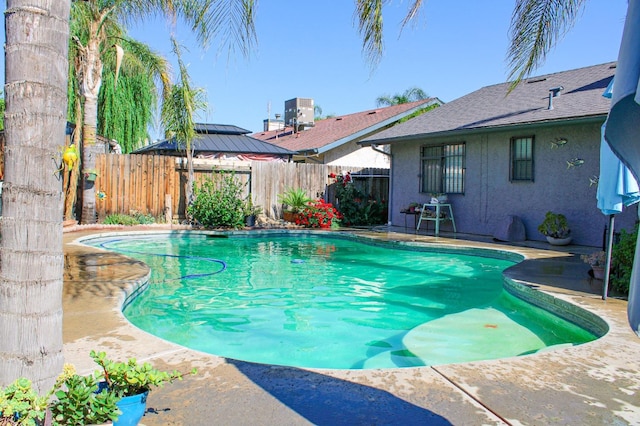 view of pool with fence, cooling unit, and a patio area