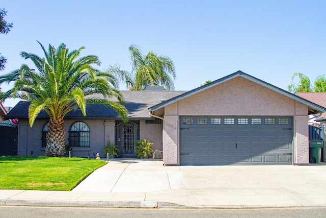 view of front facade featuring an attached garage, driveway, a front yard, and stucco siding