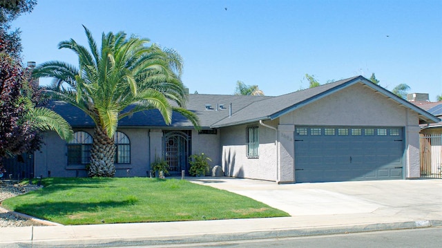3694 W Robinson Ave, Fresno, CA 93722 - ranch-style house featuring stucco siding, an attached garage, a front lawn, and concrete driveway