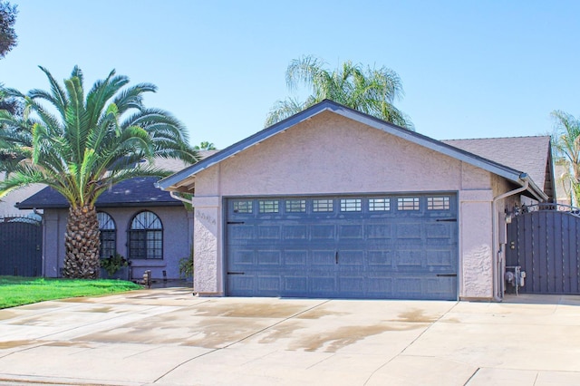 3694 W Robinson Ave, Fresno, CA 93722 - single story home with stucco siding, driveway, an attached garage, and a gate