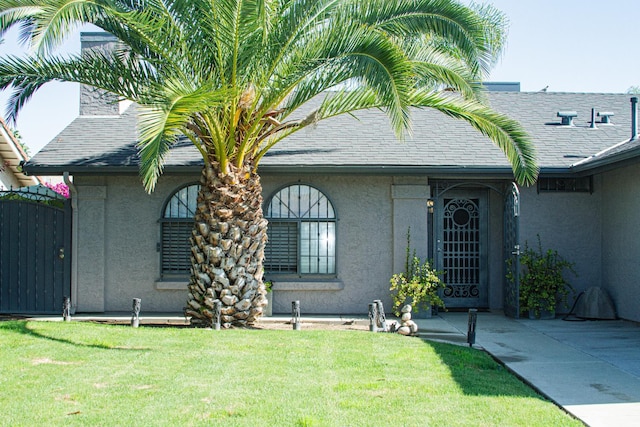 3694 W Robinson Ave, Fresno, CA 93722 - view of front of home featuring stucco siding, a front yard, and a shingled roof