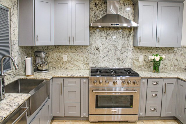 3694 W Robinson Ave, Fresno, CA 93722 - kitchen featuring wall chimney range hood, appliances with stainless steel finishes, gray cabinets, and decorative backsplash