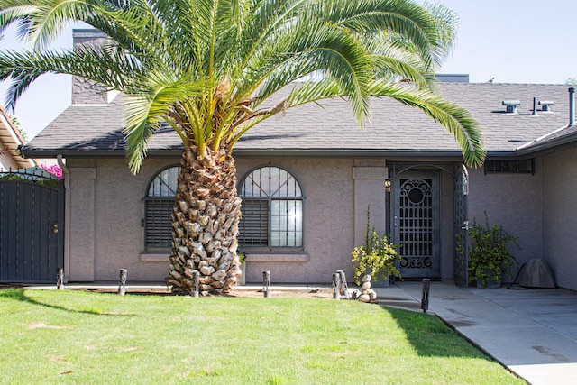 3694 W Robinson Ave, Fresno, CA 93722 - view of front of home featuring stucco siding, a front yard, and a shingled roof